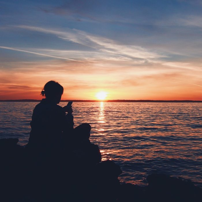 Image Of Person Sitting Out By The Water At Sunset - Search Influence