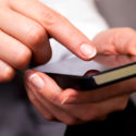 Man pointing his finger toward a smartphone's touchscreen - Search Influence