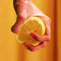 A person's hand squeezing a lemon