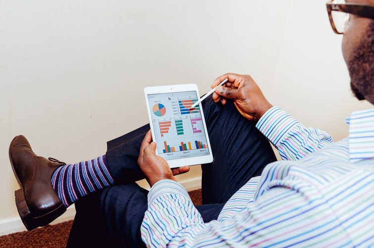 A man viewing graphs and charts on a tablet - Search Influence