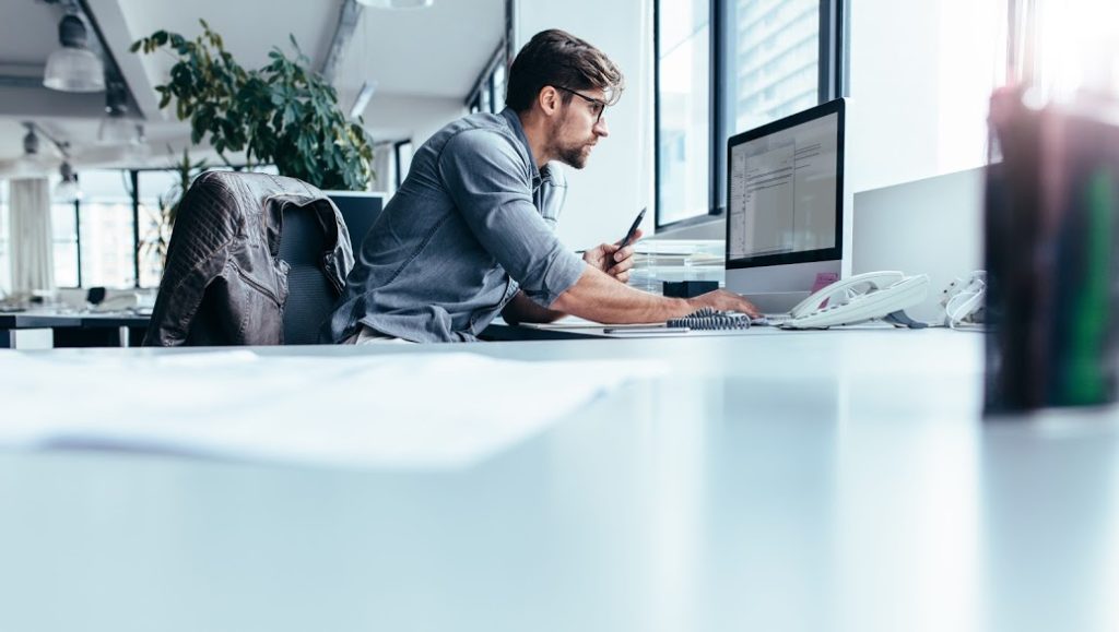 A man at a desk representing the marketing strategies of Search Influence in New Orleans, LA