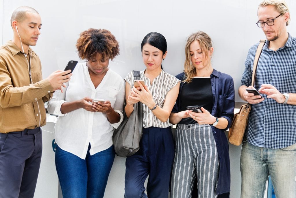 A group of people using social media on their mobile devices at Search Influence in New Orleans, LA