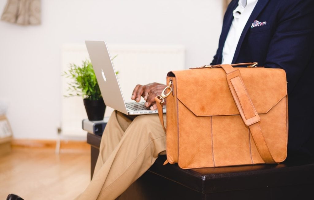 Man sitting down typing on his laptop