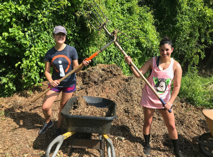 Influencers emily borne and jenna mire holding up gardening tools while volunteering