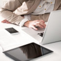 Woman working at her computer with mobile device and tablet