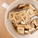 A white mug filled with Scrabble letter pieces