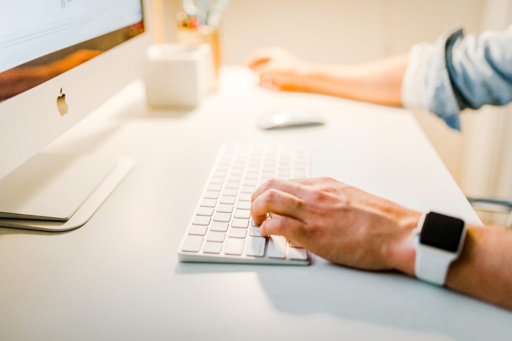 Digital marketer using keyboard at computer