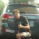 Jesse Thomas posing in front of I Love Carbs bumper sticker