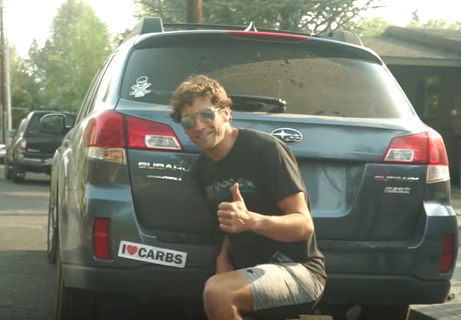 Jesse Thomas posing in front of I Love Carbs bumper sticker