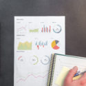 Work desk with notebook and analytics on black background