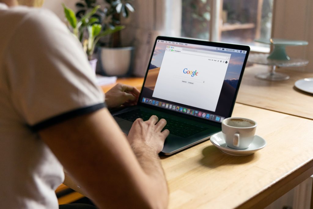 Person at desk viewing Google landing page on laptop