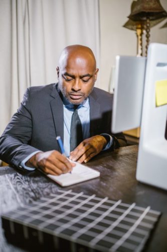 A man writing notes with a pen and paper