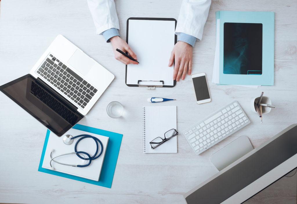 Doctor writing medical records at a desk