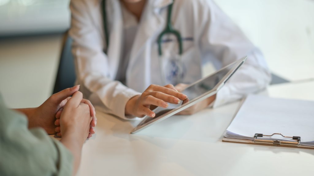 Doctor showing patient information via tablet