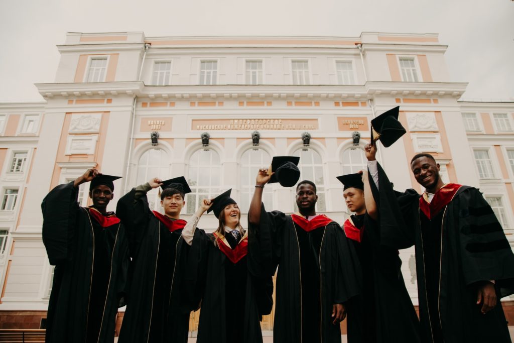 students posing while wearing caps and gowns