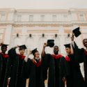 students posing while wearing caps and gowns