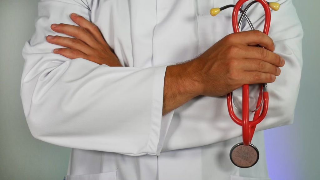 doctor in white coat holding a stethoscope