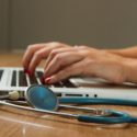 Healthcare worker typing on laptop at desk
