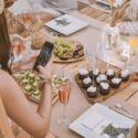 Influencer photographing dinner party for social media