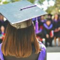 A woman looking out over her peers after graduation - Search Influence - Higher Education CPI